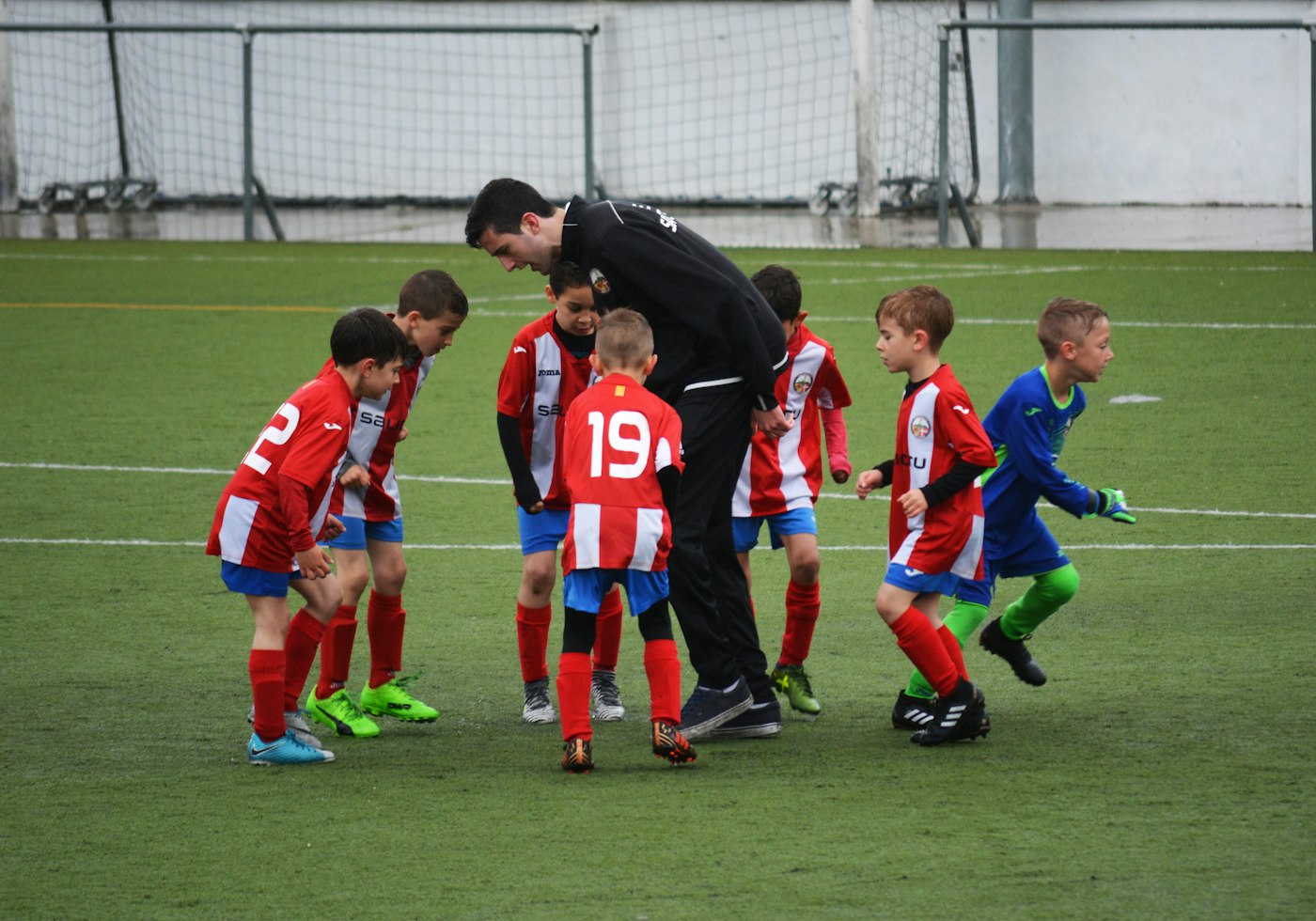 Coach guiding young footballers during a training session